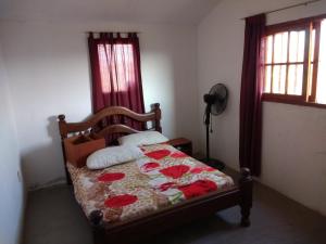 een slaapkamer met een bed met rode gordijnen bij Cabaña Siquiman in Villa Parque Siquiman