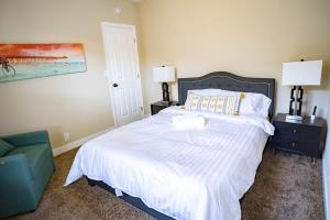 1 dormitorio con 1 cama blanca y 1 silla verde en Cozy 2BR Bungalow home nestled in the heart of LA, en Los Ángeles