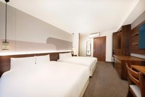 a hotel room with two beds and a desk at Hop Inn Kyoto Shijo Omiya in Kyoto