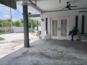 a white house with a ceiling fan and a patio at Ceri Kluang Homestay (Corner Lot) in Kluang