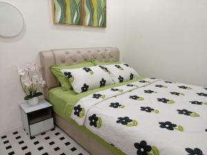 een bed met een zwart-wit dekbed en kussens bij Ceri Kluang Homestay (Corner Lot) in Kluang