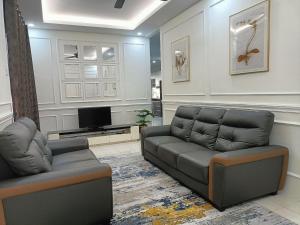 uma sala de estar com um sofá e uma televisão em Ceri Kluang Homestay (Corner Lot) em Keluang