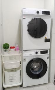 uma máquina de lavar e secar roupa ao lado de uma máquina de lavar roupa em Ceri Kluang Homestay (Corner Lot) em Keluang