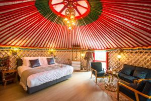 a bedroom with a bed in a circus tent at Oasis Yurt Villa @ Doi Lan - โอเอซิส เยิร์ต วิลล่า @ ดอยล้าน in Ban Huai Khai