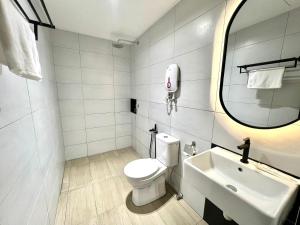a bathroom with a toilet and a sink and a mirror at Urban Inn, Serai Wangi in Padang Serai