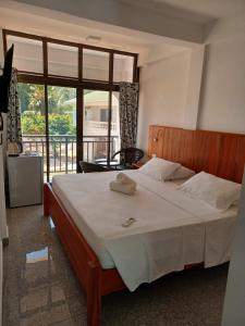 a bedroom with a large bed with a large window at Jamelah Beach Guest House in Anse aux Pins