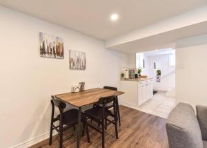 a kitchen and dining room with a table and chairs at Hidden Basement Gem: Cozy Comfort & Outdoor Fun in Barrie