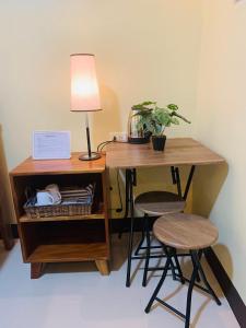 un bureau avec deux tabourets et une table avec une lampe dans l'établissement MCA Hotel Suites, à Bil-isan