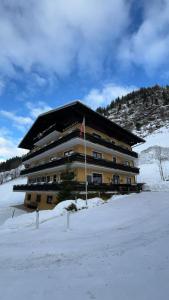 een groot gebouw met een vlag in de sneeuw bij Stubnerhof in Bad Gastein