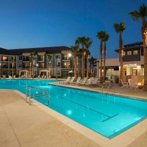 a pool at night with palm trees and buildings at Harry Potter Themed Luxury Apartment 3bd 2bth - Universal Studios in Orlando