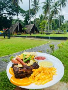 a plate of food with meat and french fries at Deduru Cabana Nature Resort in Kurunegala
