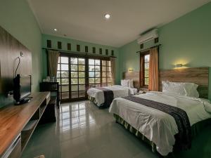 ムンドゥックにあるVILLA IPSAのベッド2台とテレビが備わるホテルルームです。