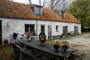 ein Haus mit einem Tisch davor in der Unterkunft B&B Hoeve de Steenoven in Damme