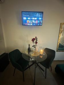 a table with two chairs and a tv on a wall at Le Plaisir Luxury Room con vasca idromassaggio in Martina Franca