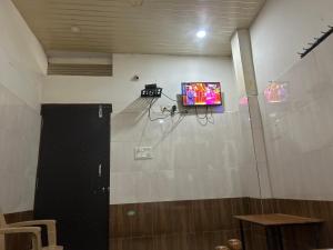 Habitación con TV en la pared en JC Residency & Lodge en Shamshabad