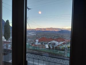 a window with a view of a city and mountains at Darwin Primula in Konitsa