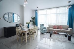 a living room with a table and a couch at Two Continents Holiday Homes - Marina View Three Bedroom Apartment in Dubai