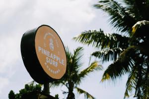 um sinal na frente de algumas palmeiras em PineApple Surf em Ahangama