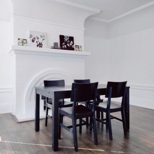 a black dining room table with black chairs and a fireplace at Sunny SF home - cozy, spacious, convenient w/parking, A+ location!! in San Francisco