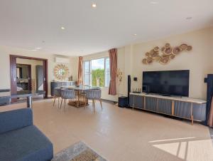 象島的住宿－馬尼普拉別墅，客厅配有电视和桌椅