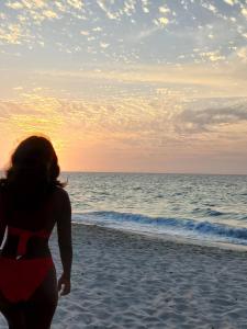 Una donna in piedi sulla spiaggia che guarda l'oceano di Hugos Place Baru a Cartagena de Indias