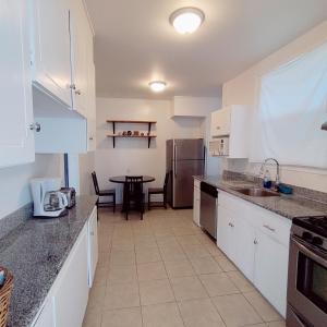 a kitchen with white cabinets and a table in it at Sunny SF home - cozy, spacious, convenient w/parking, A+ location!! in San Francisco