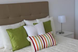 łóżko z zielonymi i białymi poduszkami w obiekcie Mel Apartment w Funchal