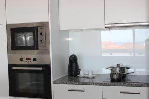 a kitchen with a microwave and a stove top oven at Mel Apartment in Funchal