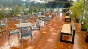 an empty restaurant with tables and chairs and plants at THE RIVIERA in Theni