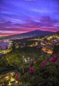 Blick auf eine Stadt in der Nacht mit einem Berg in der Unterkunft CASA VACANZE PIEKNY DOM DWA in Taormina