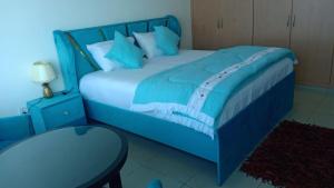 ein blaues Schlafzimmer mit einem blauen Bett und einem Tisch in der Unterkunft FT22 R3 Open beach ajman washroom is outside in Ajman 