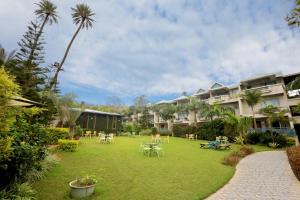 a large yard with tables and chairs and buildings at Hummingbird Resort in Mount Ābu