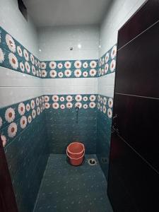 een badkamer met een emmer in de hoek van een kamer bij Shri Sarvad AC Rooms & Dormitory in Varanasi