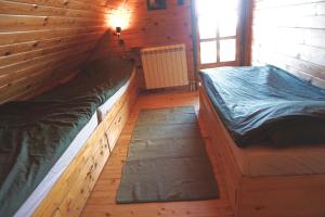 a room with two beds in a wooden cabin at Cozy chalet Montana in Kopaonik