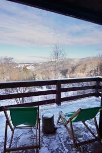 due sedie sedute su un portico nella neve di Cozy chalet Montana a Kopaonik