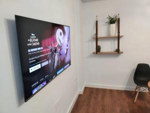 a flat screen tv hanging on a white wall at Oasis-Triana's Hallway in Camas