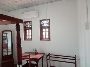 a dining room with a table and two windows at Leisure Home Mirissa in Mirissa