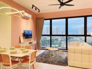 a living room with a table and a large window at Jovial Modern&Stylish `UrbanSuites in Jelutong