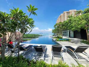 a view of a river with chairs and trees at Jovial Modern&Stylish `UrbanSuites in Jelutong