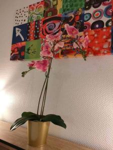 un jarrón con flores rosas sentado en una mesa en Appartement au calme ORSAY PARIS, en Orsay