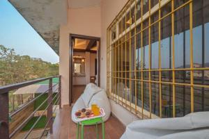 een balkon met een stoel en een dienblad met eten bij VG villa 04 in Lonavala