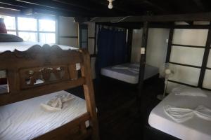 a room with three bunk beds and a window at Hugos Place Baru in Cartagena de Indias