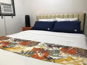 Una cama con una manta de colores encima. en Mikhai Guest House near Las Cazas de Acuzar, en Bagac