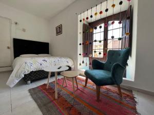 a bedroom with a bed and a chair and a table at Cusco Plaza de Armas in Cusco