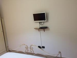a tv sitting on a wall next to a bed at Apartment Largo del Teatro in Porto San Giorgio