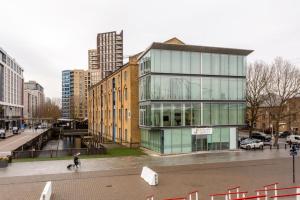 a person walking past a building in a city at Luxury 1Bed In Converted Warehouse Next To London Excel in London