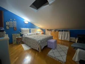 een slaapkamer met een bed en een blauwe muur bij Soggiorno da Fiore in Monte Rubiaglio