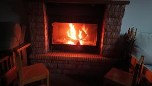 a brick fireplace with a fire in it at Adonis Guest House in Dimitsana
