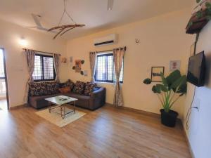 a living room with a couch and a table at 2bhk Bunglow with terrace- Candolim in Candolim