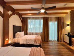 1 dormitorio con 2 camas y ventilador de techo en Lee Boutique Hotel Baguio, en Baguio